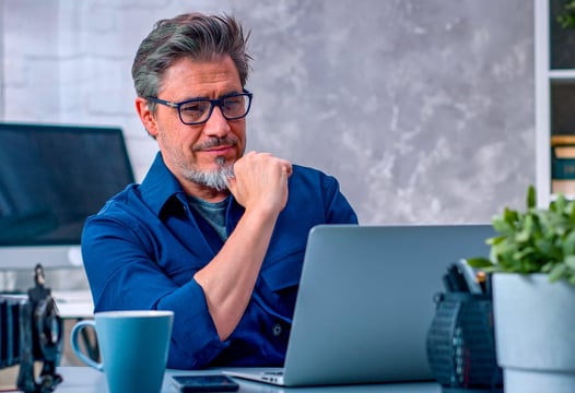 Hombre revisando información en su computador portátil.