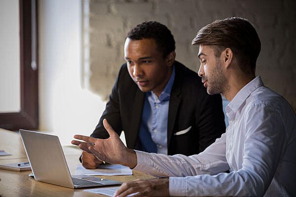 Dos hombres estudiando el curso servicio al cliente de Colsubsidio