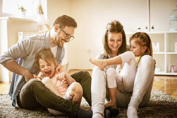 Padres y sus dos hijas juegan en la casa que compraron con el crédito de vivienda Colsubsidio