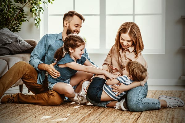Pareja feliz, jugando con sus hijos en su nueva casa.