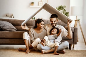 Una familia afro compartiendo en la comodidad de su hogar gracias a la protección que les brinda Colsubsidio.