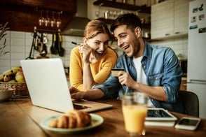 Una pareja de hombre y mujer felices, realizando sus compras con su tarjeta de crédito.