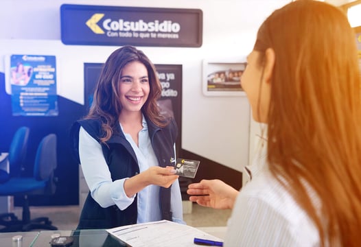 Mujer adquiriendo su tarjeta de afiliación Colsubsidio