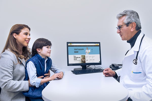 Madre y a su hijo atiende consulta con un médico.
