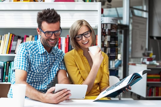 Una pareja de compañeros de trabajo está navegando la sección de Biblioteca Digital de Colsubsidio