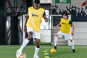 Jóvenes jugando fútbol en cancha sintética