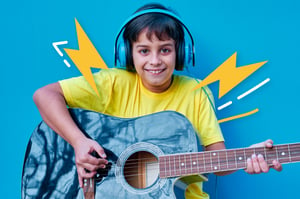 Un niño feliz, aprendiendo a tocar guitarra.