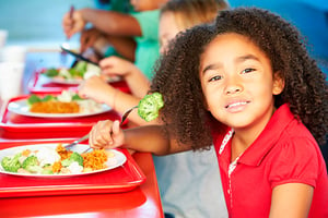 Una niña afroamericana, almorzando en uno de nuestros colegios de Colsubsidio.