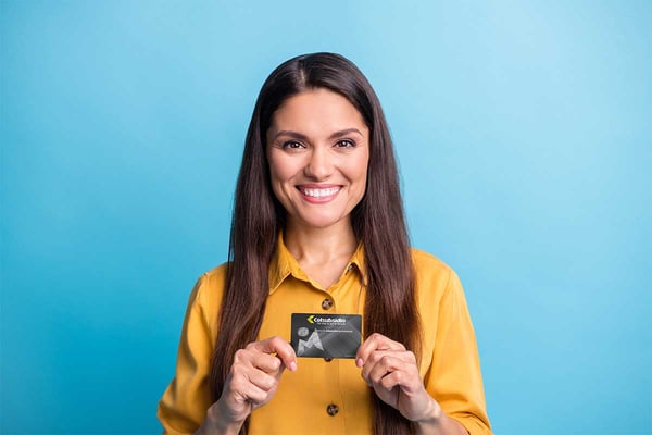 Mujer feliz sosteniendo en sus manos la Tarjeta Multiservicios