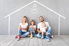 Familia feliz sentados en el piso de su nuevo hogar.