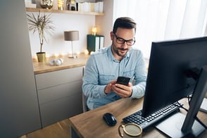 Hombre joven con su teléfono, realizando pagos en línea