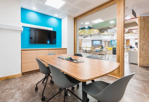 Sala de reuniones equipadas con televisor, mesas de trabajo y wifi del Centro para el Desarrollo Empresarial y del Talento de Colsubsidio.