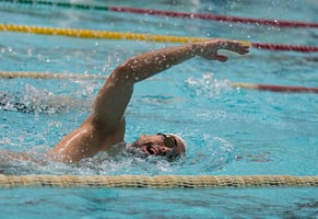 Un hombre compitiendo en el deporte de natación.