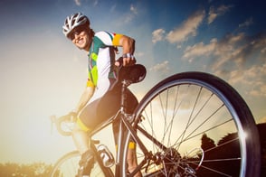 Una persona con su equipo de ciclismo, montado en su bicicleta.