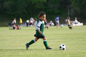 Una niña practicando fútbol en nuestras canchas de Colsubsidio.