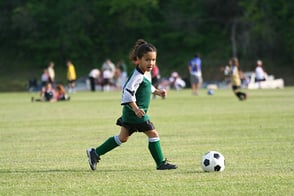 Una niña practicando fútbol en nuestras canchas de Colsubsidio.