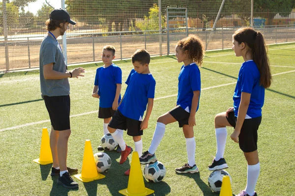 Grupo de niños y niñas entrenamiento futbol en escuela deportiva Colsubsidio.