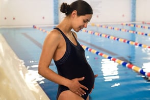 Madre gestante al lado de una piscina disfrutando de las instalaciones de Colsubsidio en el programa para Madres Gestantes 