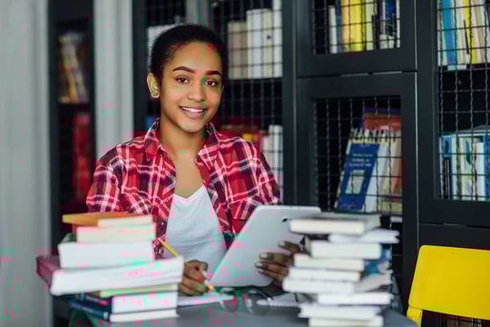 Una niña afroamericana, estudiando en una biblioteca.