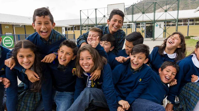 Grupo de estudiantes sonriendo en las instalaciones de su colegio.