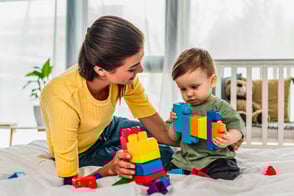 Madre realizando ejercicios de estimulación con su bebé.