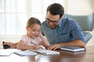 Un padre ayudando a su hija con sus tareas escolares.