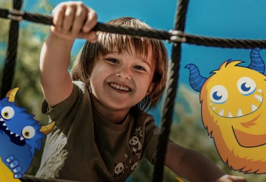 Un niño feliz, jugando en un parque de diversiones.