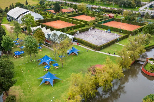 Vista aérea del Club Bellavista donde se observan sus zonas verdes y tres canchas de tenis.