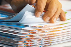 Una persona buscando información en un paquete de documentos.