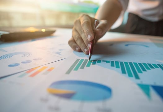 Una persona revisando datos estadísticos en boletines informativos.