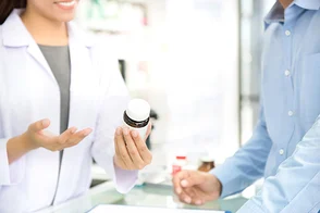 Una farmaceuta entregando medicamentos a un usuario de Colsubsidio.