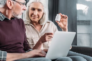 Dos personas ancianas revisando sus recetas médicas en el portal de salud de Colsubsidio.