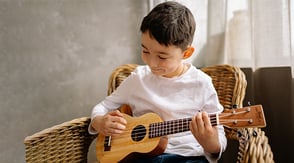 Niño tocando guitarra en las escuelas de Teatro Colsubsidio.