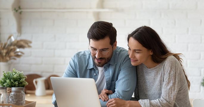 Pareja ve pantalla de computador portátil