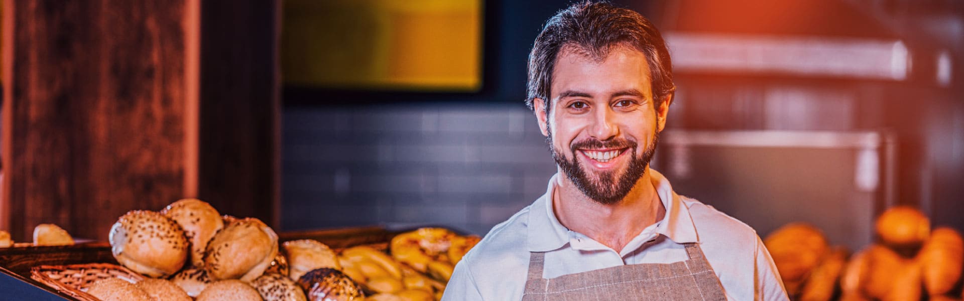 Hombre sonriendo, trabajando en su panadería