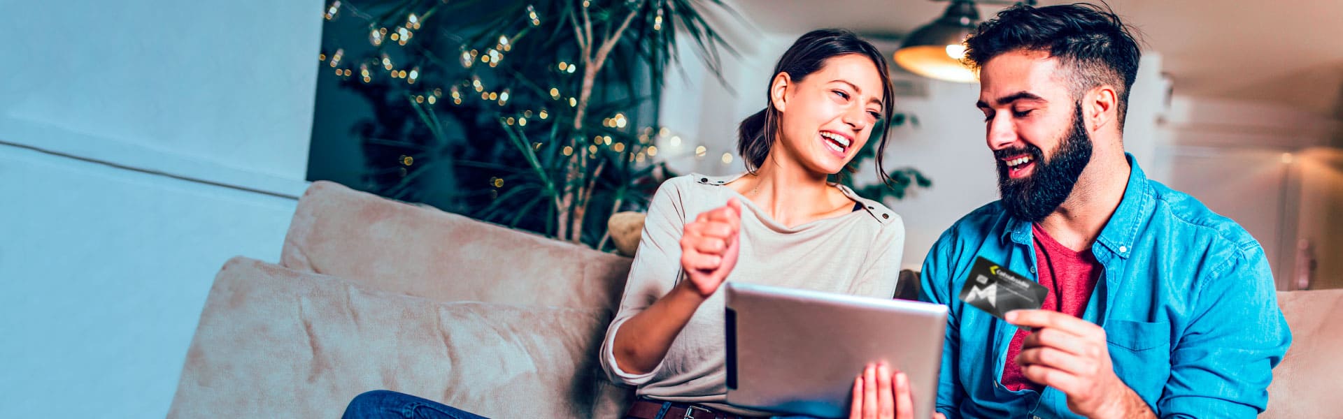 Una pareja de hombre y mujer, feliz revisando su crédito de libre inversión en una tablet.