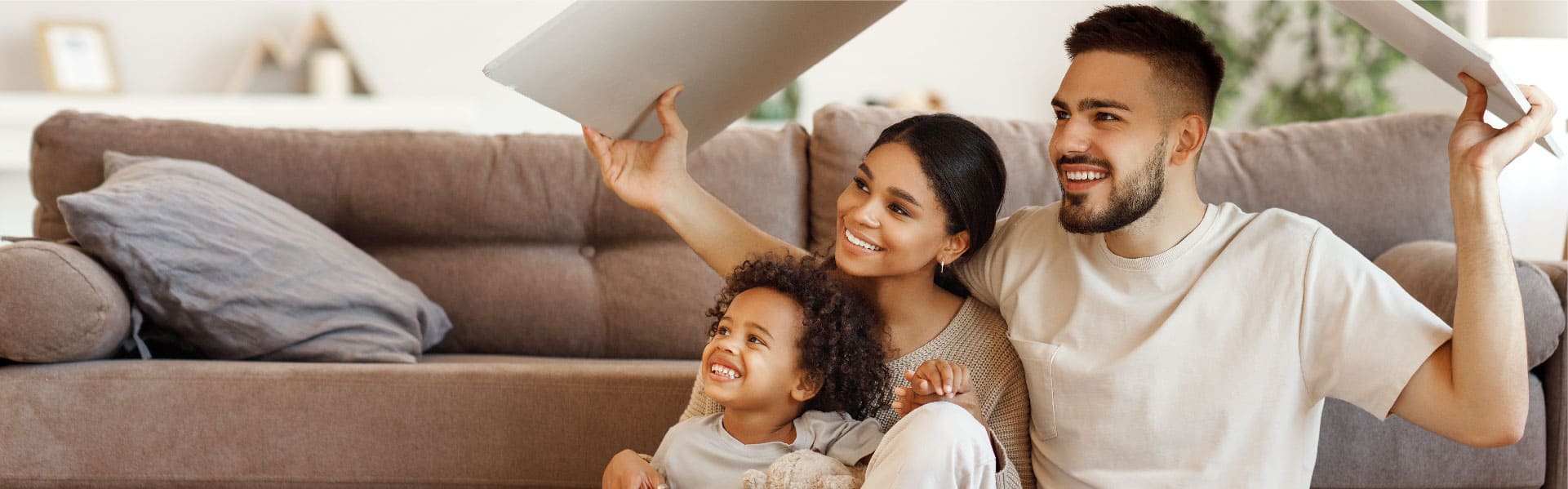 Una familia feliz, sentada en la sala de su nuevo hogar.