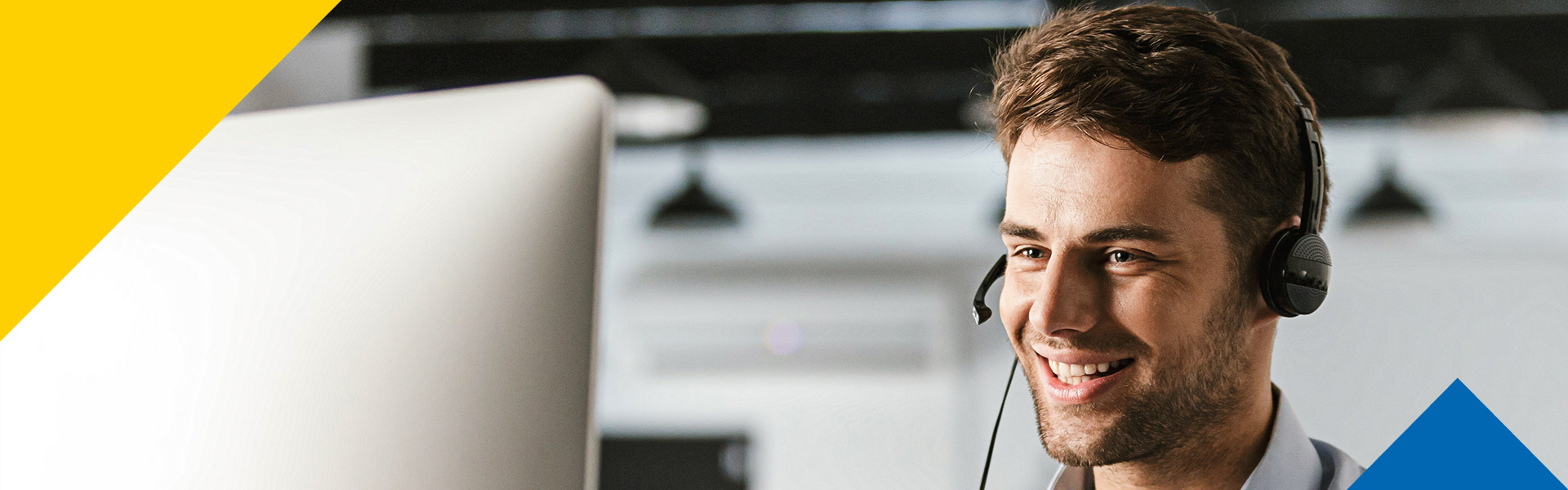 Un hombre con diademas, asesorando a usuarios en un call center.