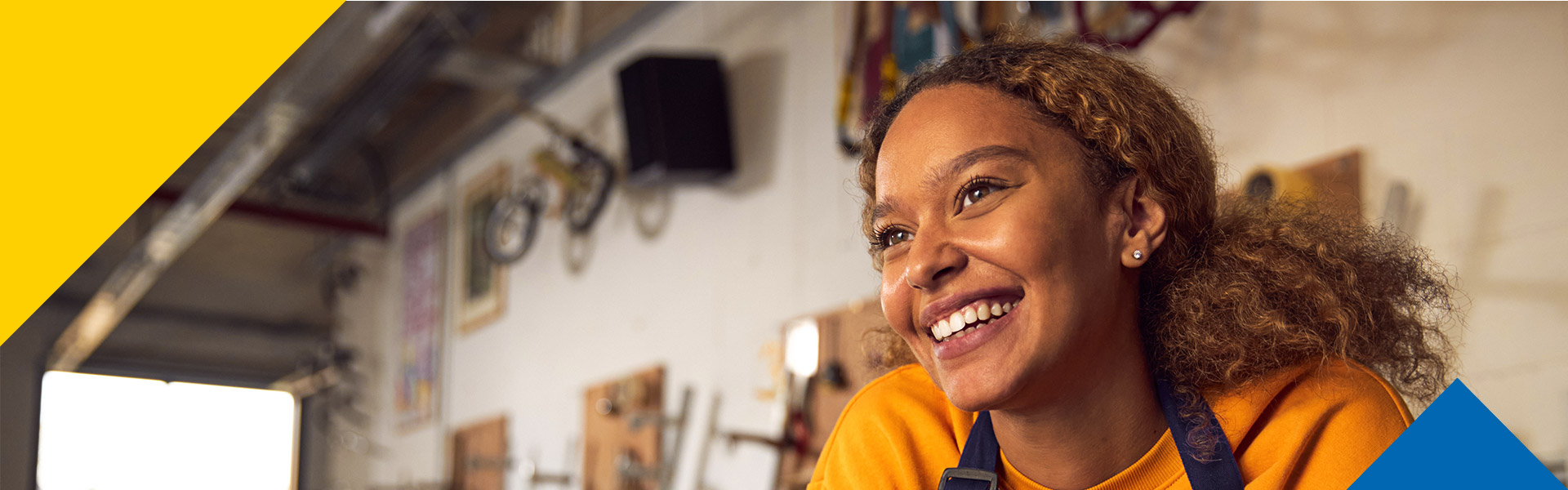 Mujer afroamericana sonriente en su sitio de trabajo gracias a las oportunidades de empleo Colsubsidio.