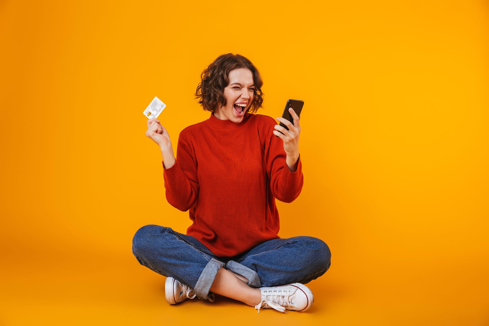 Una mujer feliz de realizar sus compras seguras con su tarjeta de crédito.