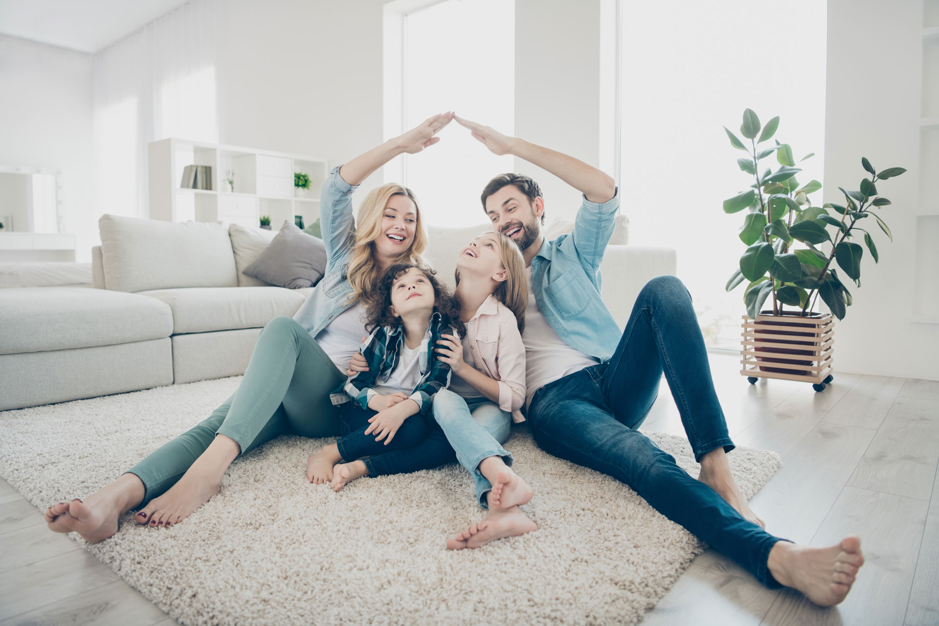 Una pareja y sus hijos pequeños, disfrutando su compañía en la comodidad de su hogar.