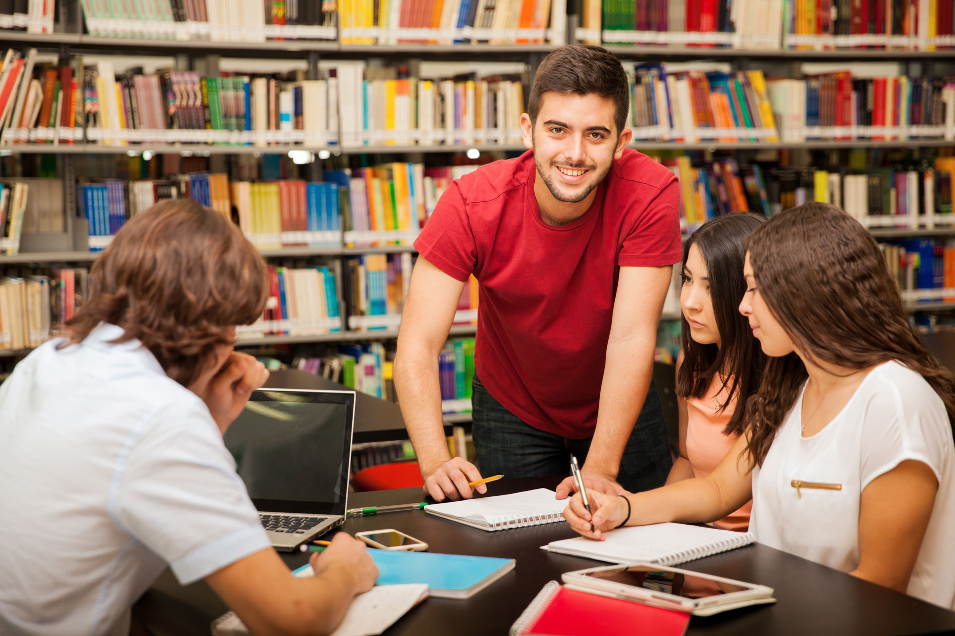 Un grupo de jóvenes estudiando en la biblioteca de su universidad.