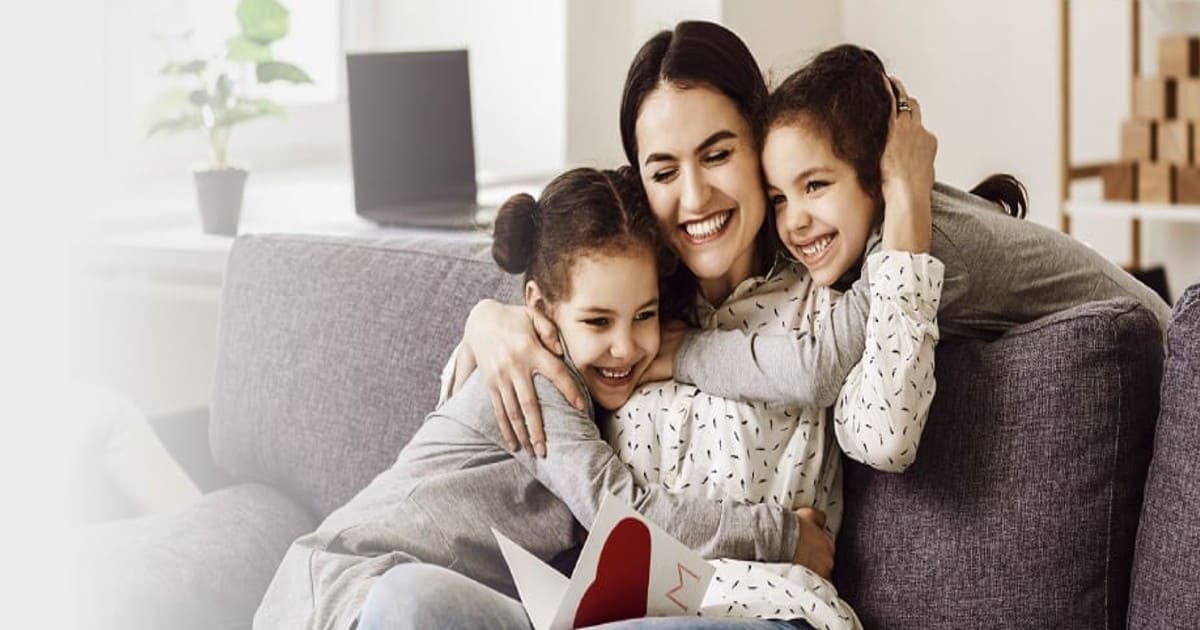 Madre con sus hijos en la sala disfrutando de los beneficios otorgados por Colsubsidio para su vivienda nueva.