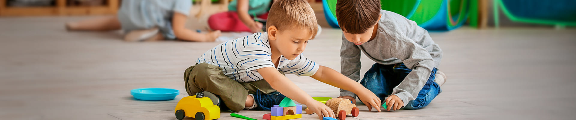 Dos niños jugando con sus juguetes en un parque de diversiones.