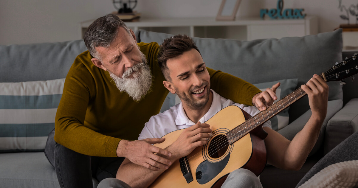 Un padre enseñando a tocar guitarra a su hijo en Colsubsidio. 