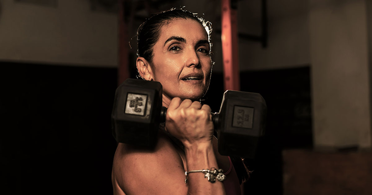 Mujer sosteniendo una pesa en los gimnasios de Colsubsidio. 