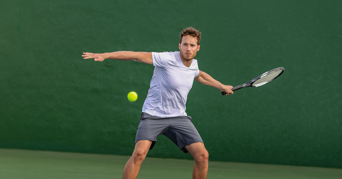 Un hombre joven jugando tenis de campo en las canchas de los Clubes Colsubsidio. 