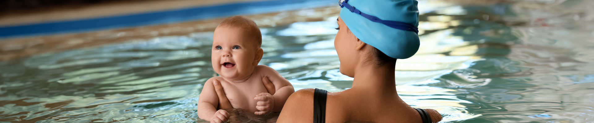 La mamá con su bebé realizando una práctica libre de natación.