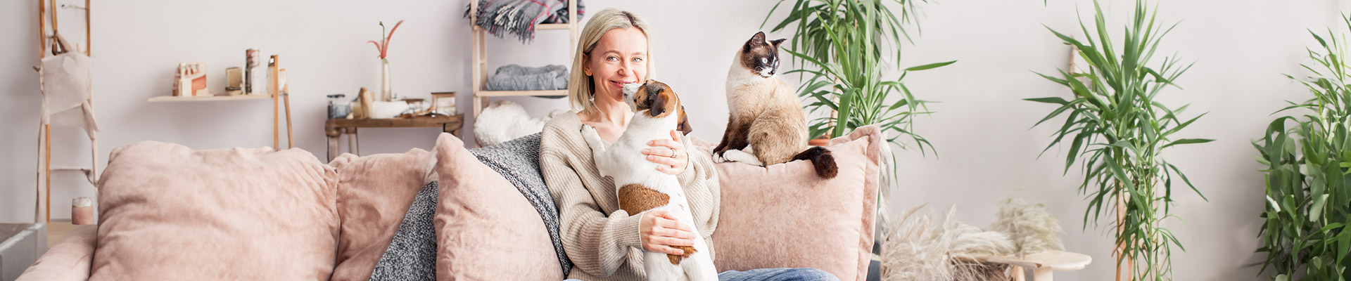 Una mujer sentada en el sofa con sus mascotas 