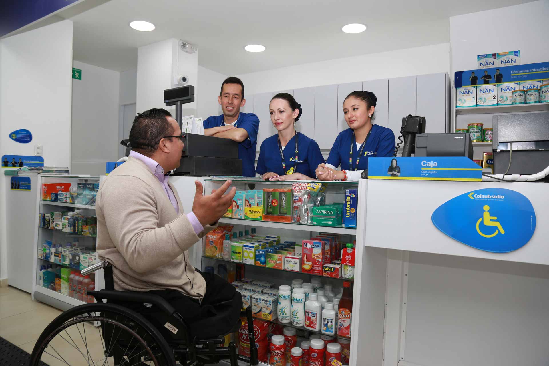 Un equipo de farmaceutas atendiendo a una persona con discapacidad.